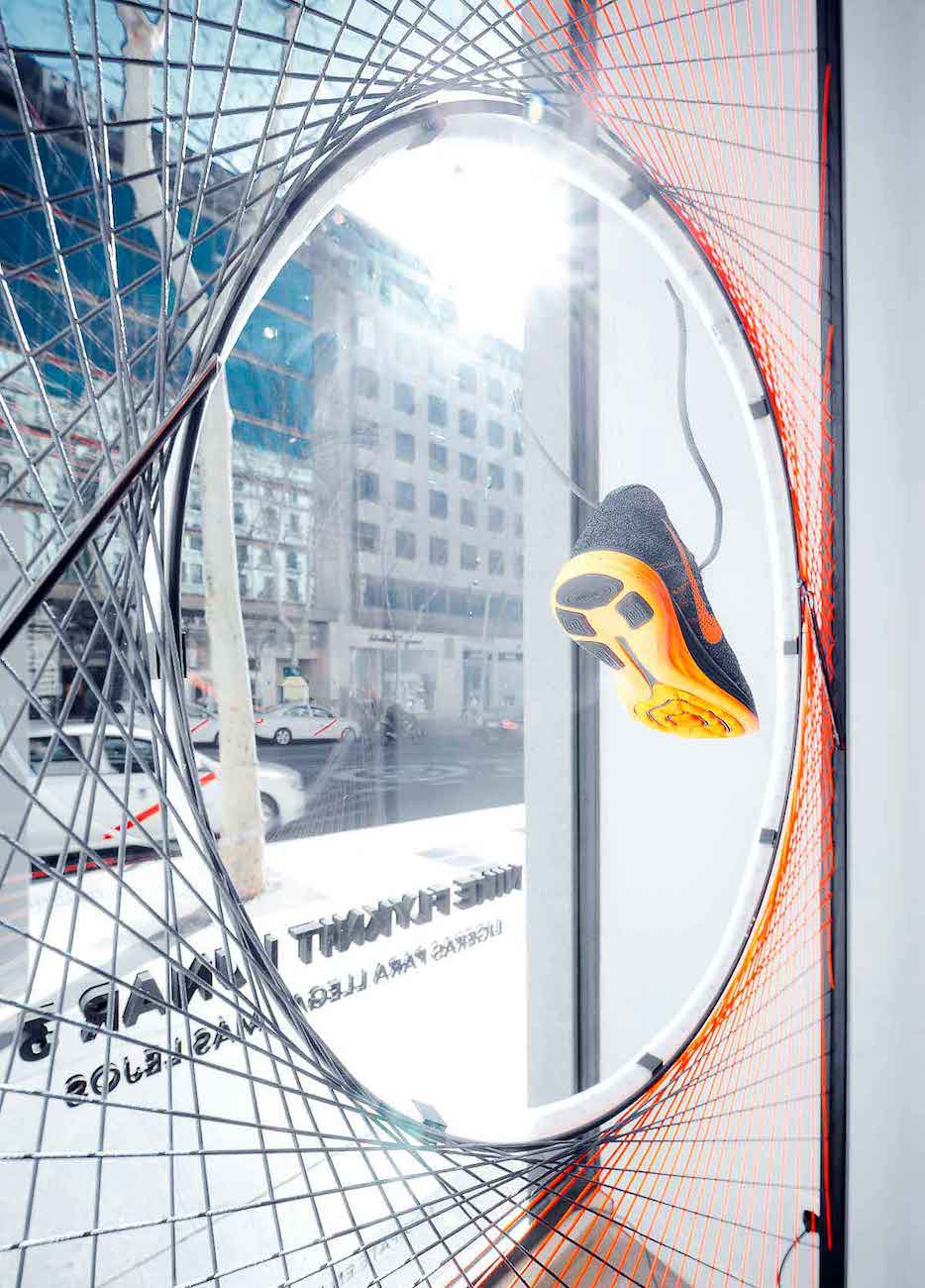 Escaparate con estructura metalica con hilos y neón tienda Nike en Madrid