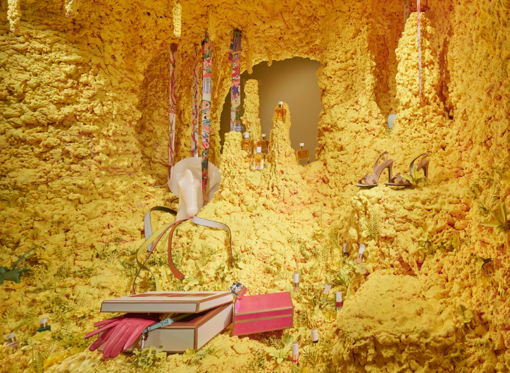 Hermès tropical summer window display with lush greenery in vibrant tones, conveying freshness and colour for summer retail.