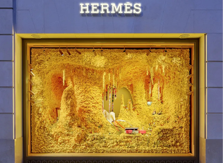 Hermès summer installation with references to the tropics and natural materials in a vibrant, eye-catching window display.