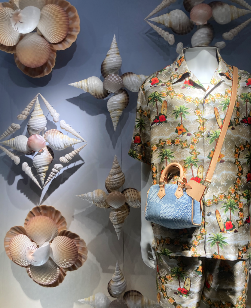 Louis Vuitton window display with a marine design, with large shells enveloping bags and accessories from the summer collection.